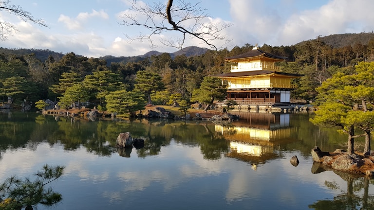 Evening view of Kinkaku-ji reflecting on the tranquil pond under a soft sky.