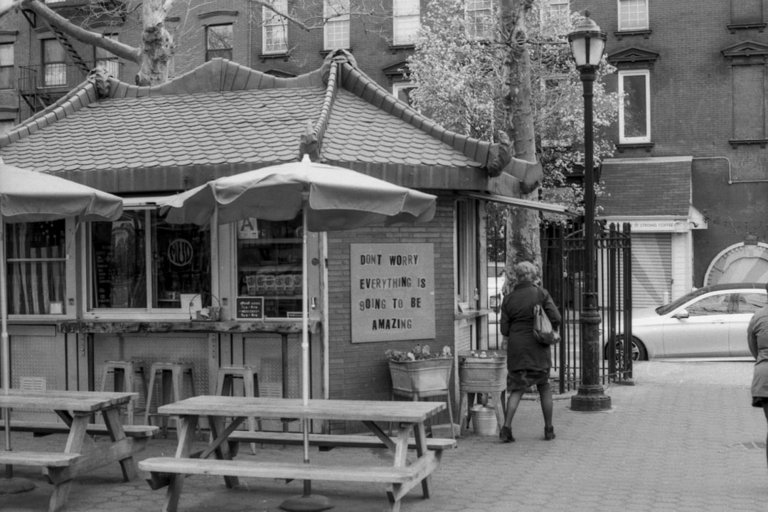 woman standing near store in grayscale photo