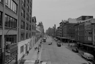 A serene black and white photograph capturing a quiet urban street scene.