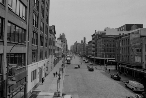A black and white photograph of a serene urban street scene.