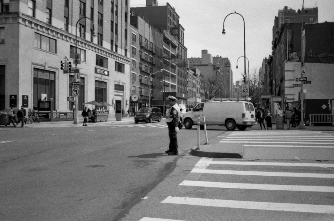 grayscale photography of man standing in middle of street