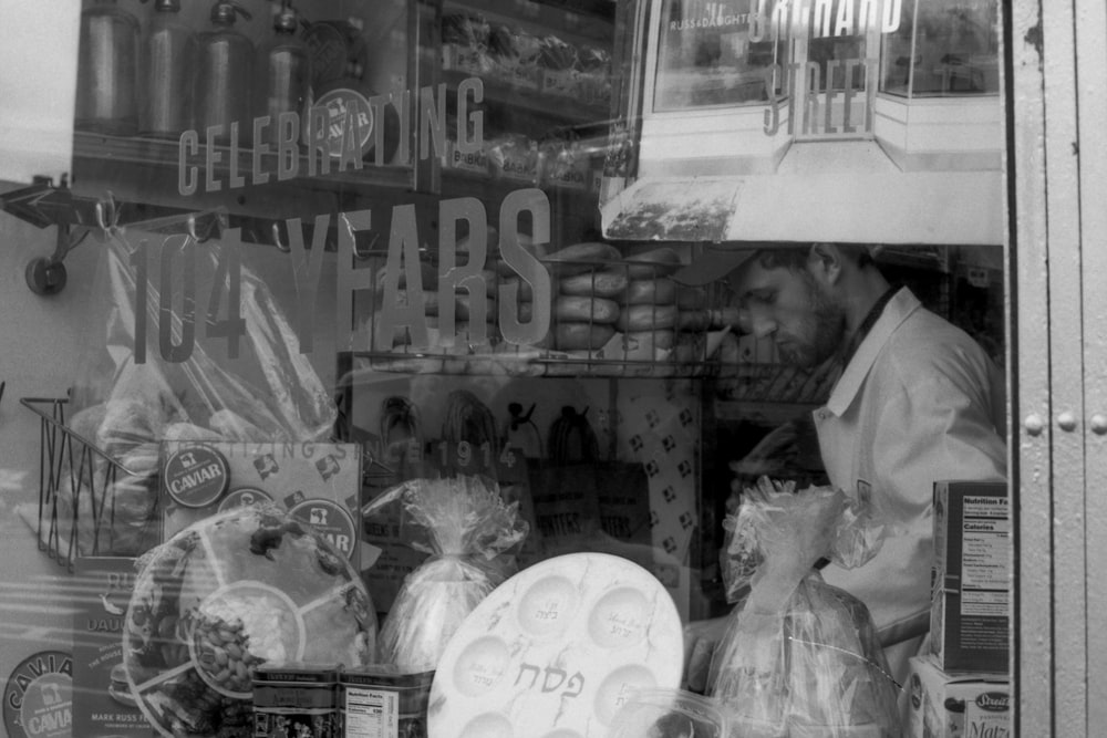 grayscale photography of man inside store