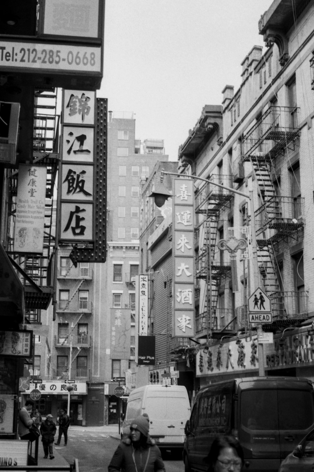 vehicle on street surrounded with buildings grayscale photography