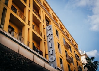 A welcoming Capitol Holdings agent shaking hands with a happy client in front of a modern office building.
