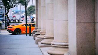 gray concrete pillars beside orange vehicle