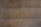 A close-up view of a brown leather surface with two parallel rows of dark stitching running horizontally across it. The texture of the leather is visible, with slight imperfections and a matte finish. The stitching appears uniform and evenly spaced.