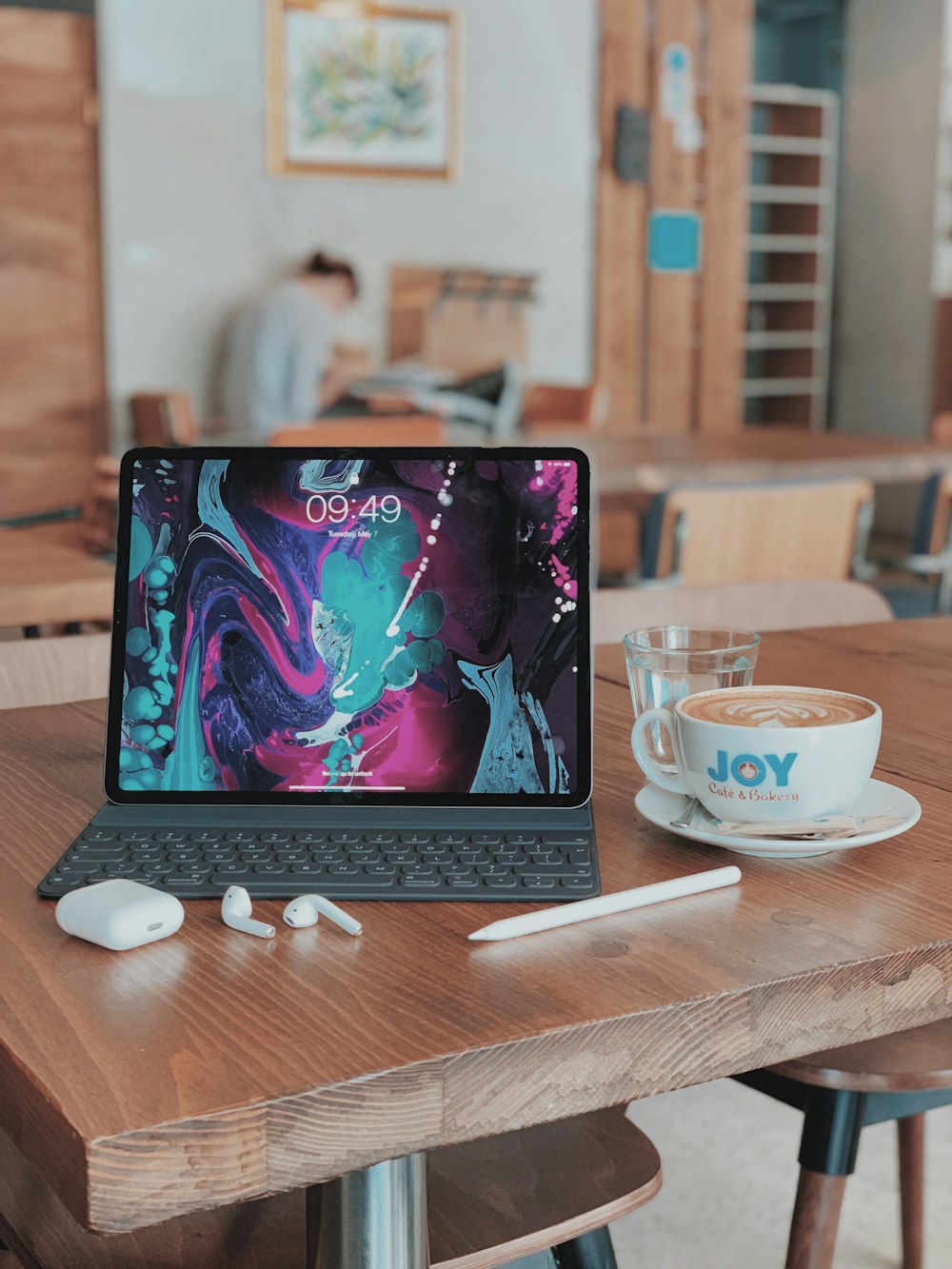 black iPad beside cup of coffee on table