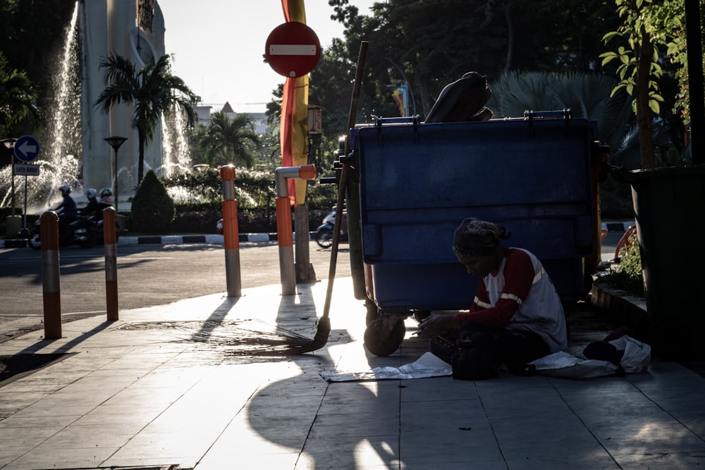 man sitting on sidewalk