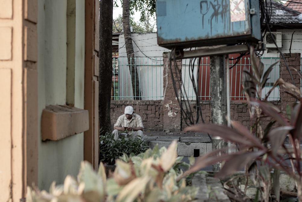 man seated by a brown wall