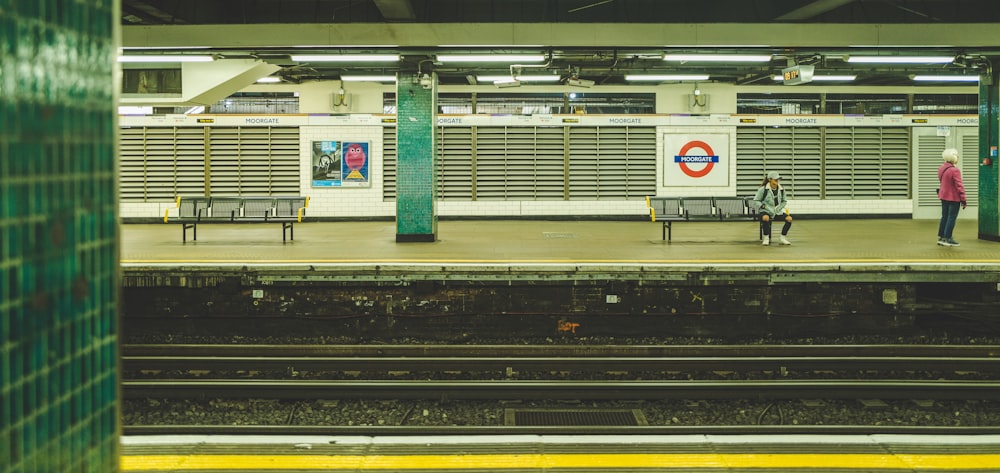 two people waiting on a subway station