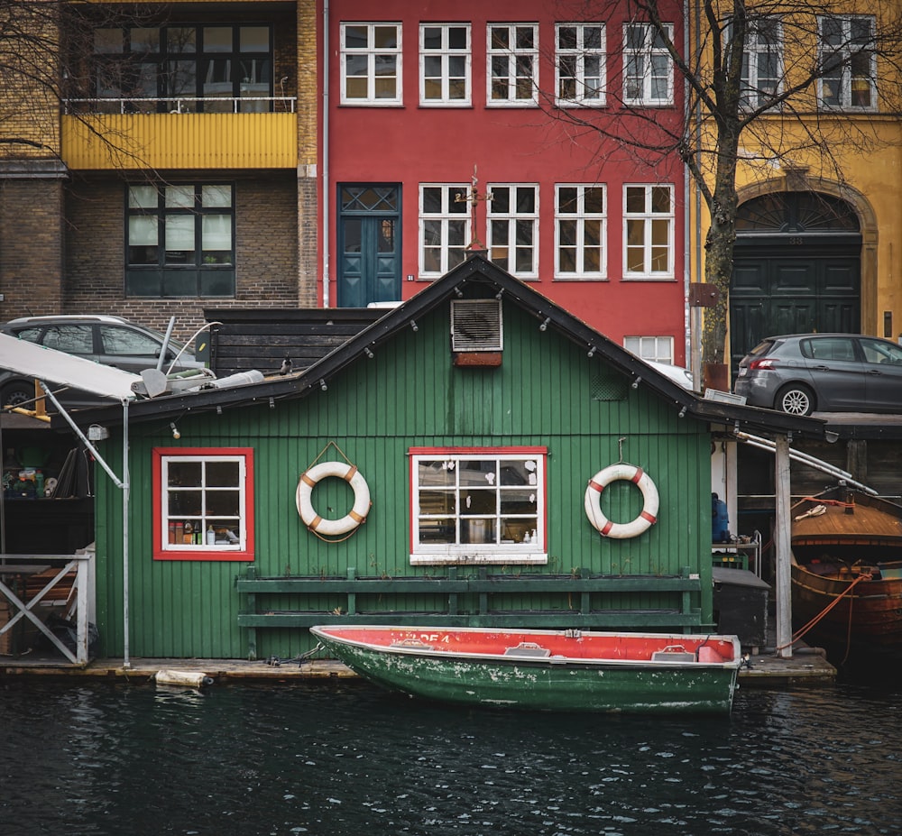 boat floating on water in front of a house