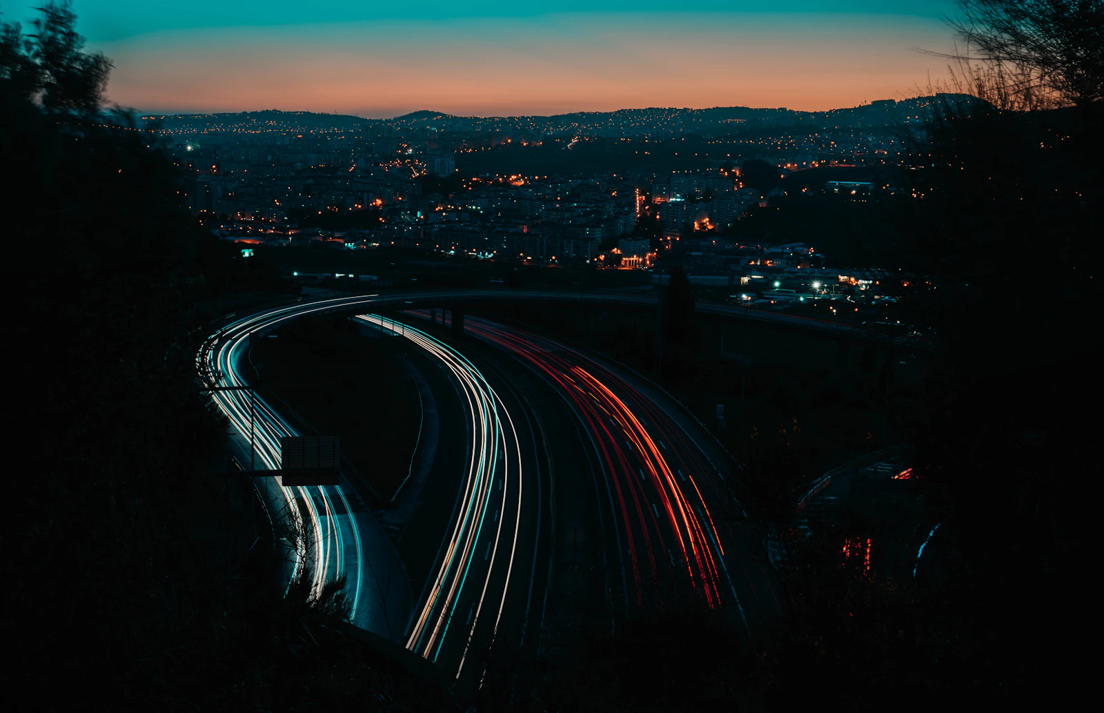 Vehicle lights trace a Portuguese urban road at night