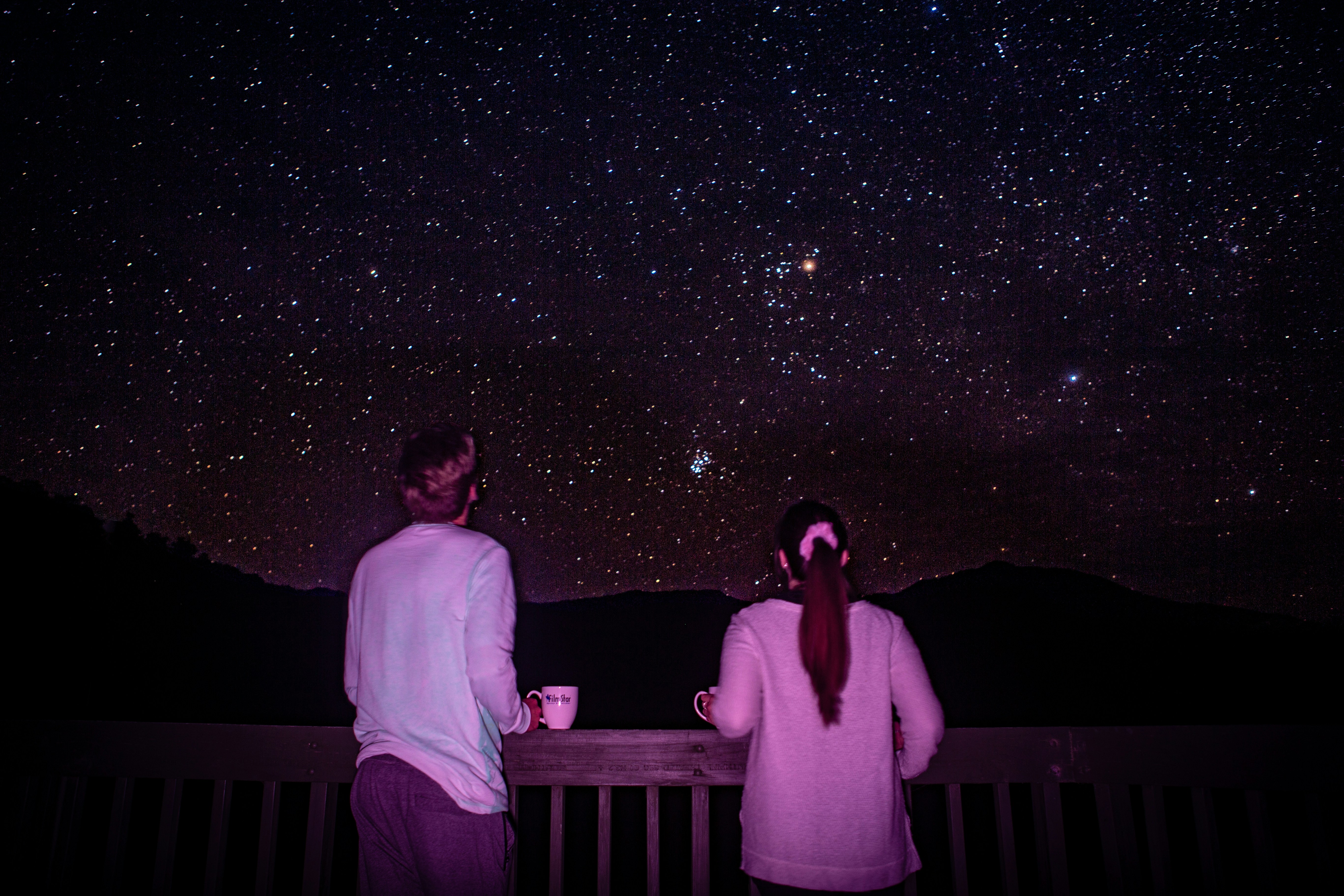 man and woman standing in front of galaxy, 