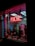 A storefront features a prominently displayed neon sign with the word 'PSYCHIC' in bright red. The window is adorned with red string lights and contains various decorative items, including statues and plants. A poster inside provides additional information on psychic services.