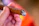 Close-up of a hand holding a lit Ahav cigar with soft smoke curling upwards.