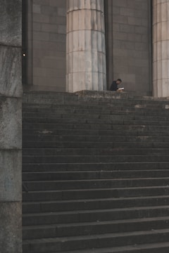 man standing beside pedestal column