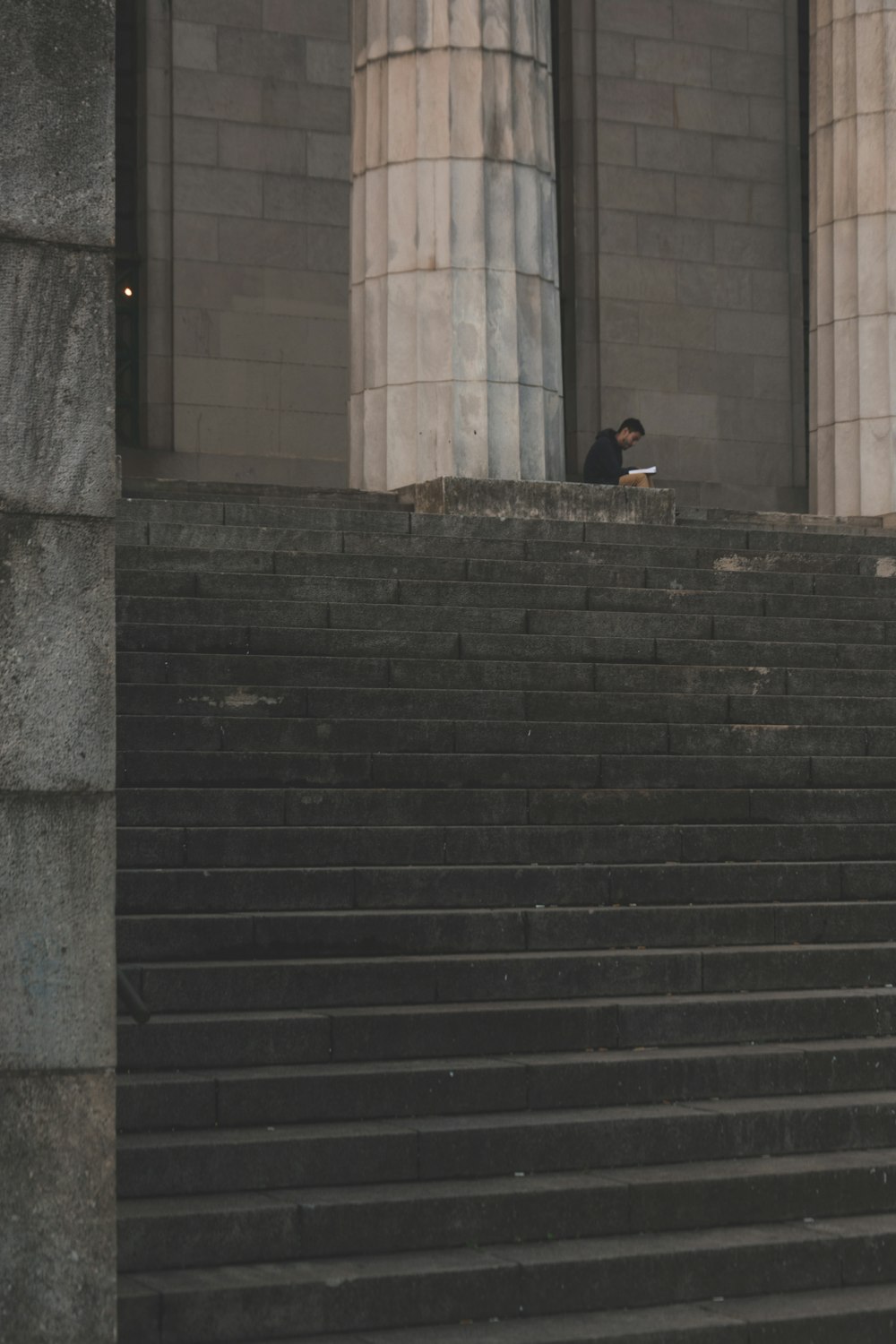 man standing beside pedestal column