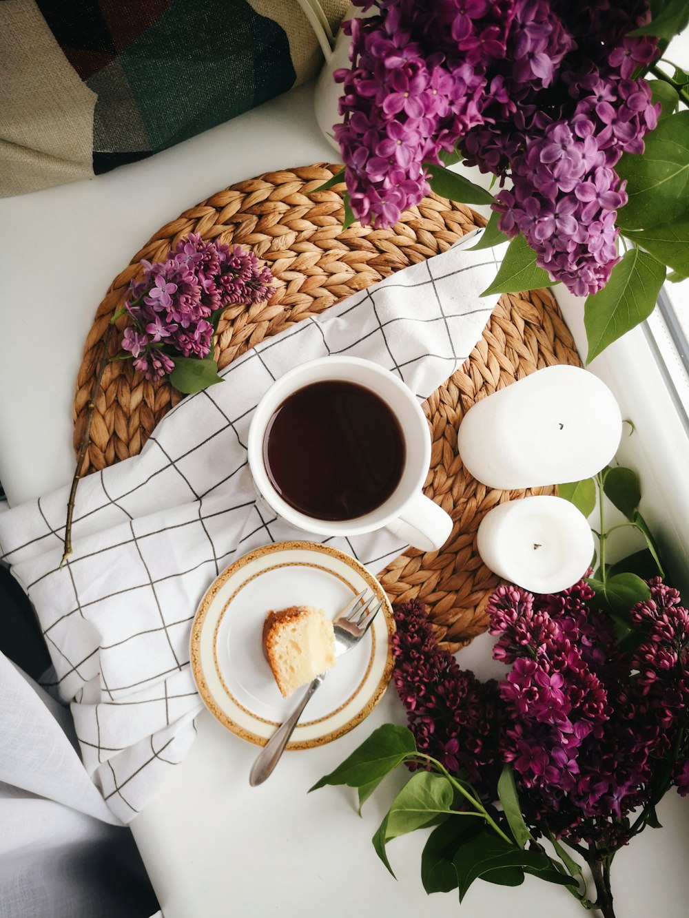 high angle photo of coffee in mug beside food and candles