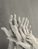 grayscale photo of family's hands