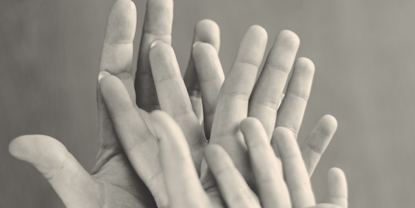 grayscale photo of family's hands