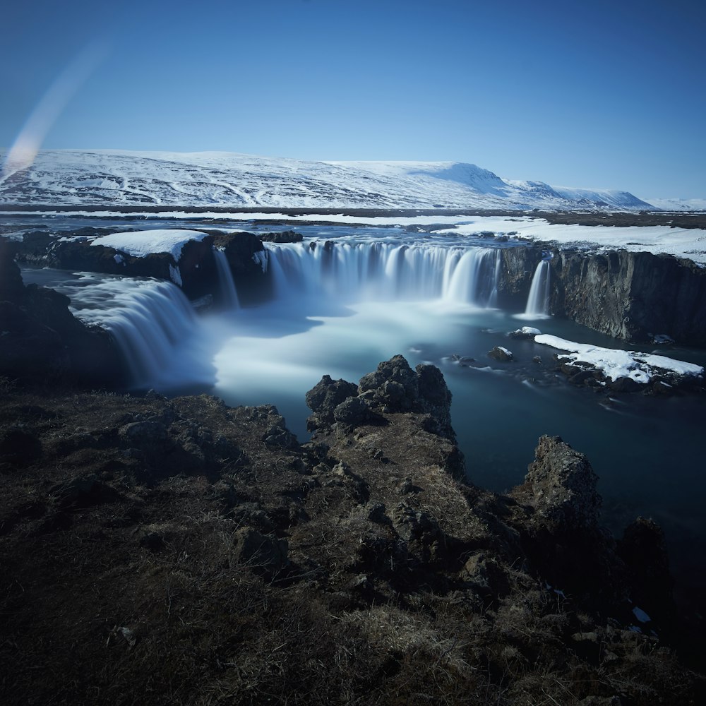 chutes d’eau près d’un terrain pendant la journée