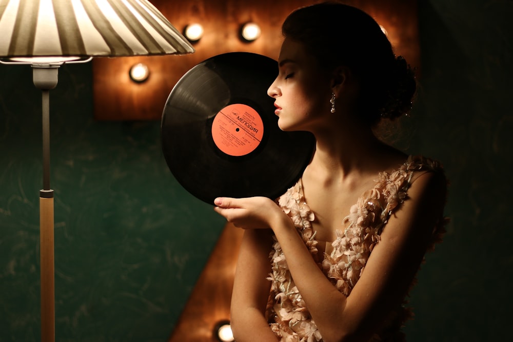 shallow focus photo of woman holding vinyl record