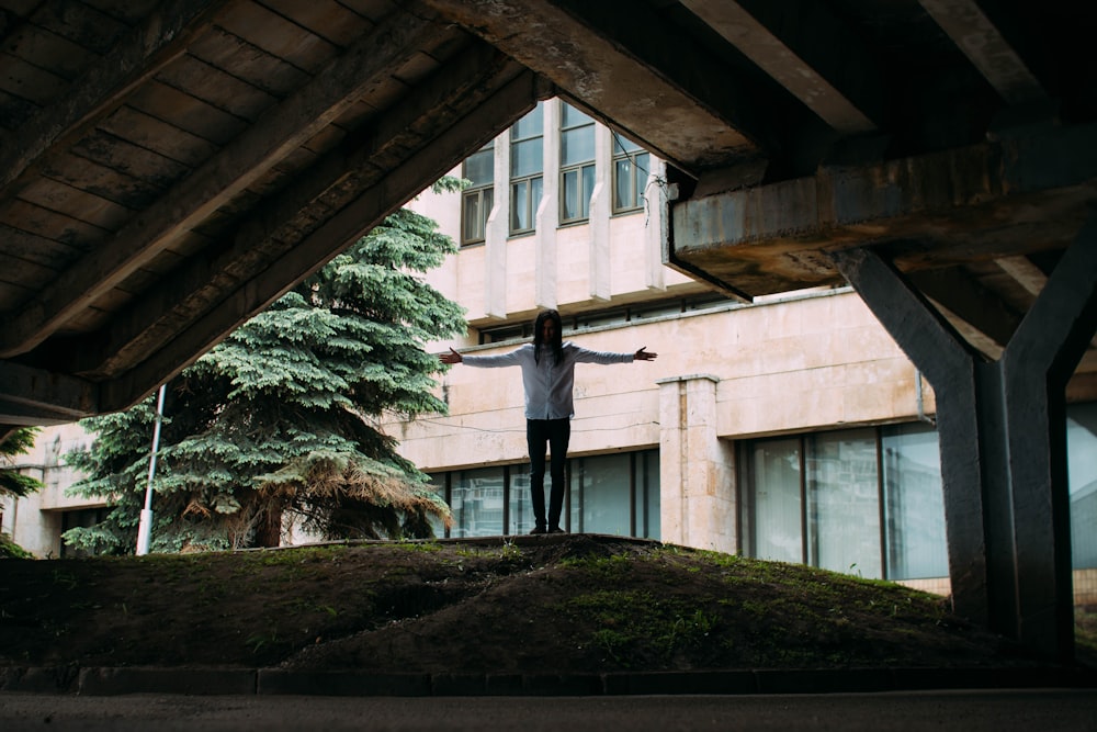 man wearing white dress shirt under bridge