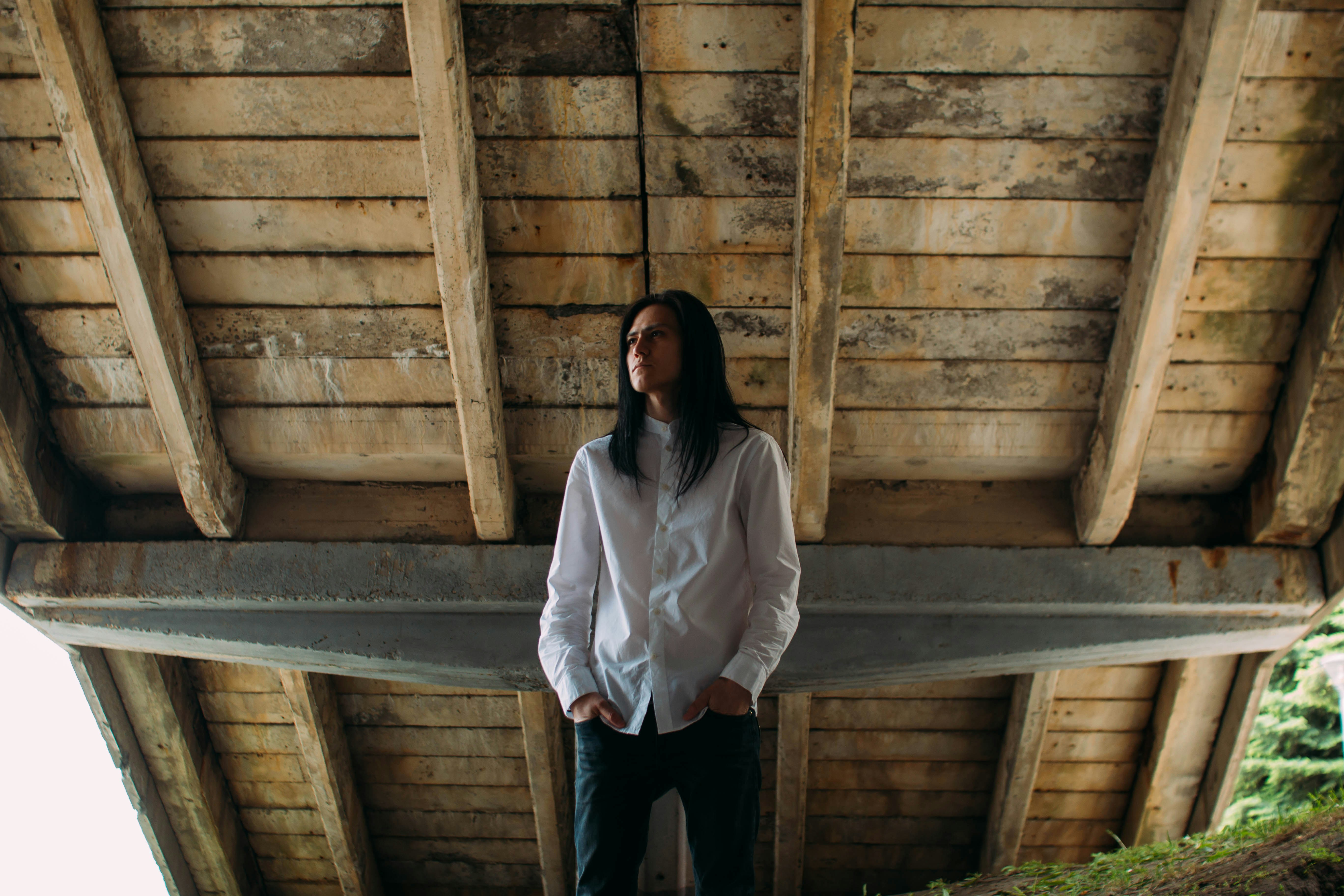 Mann trägt weißes Hemd unter braunem Holzbrett