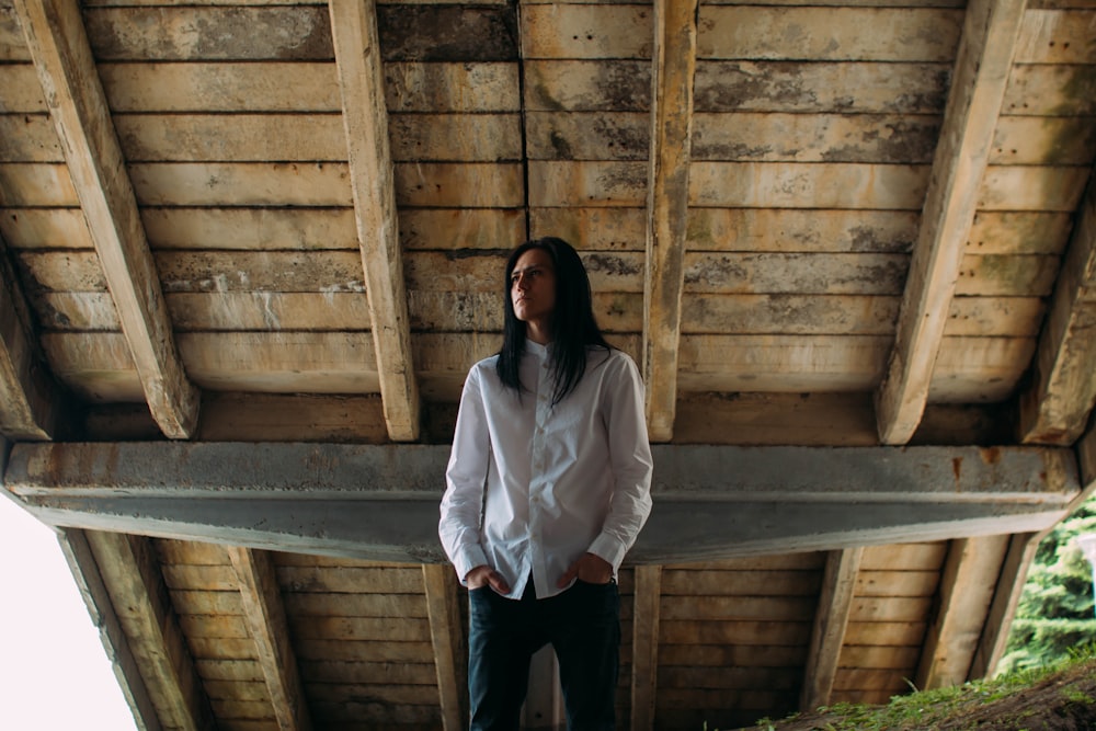 man wearing white dress shirt under brown wooden board