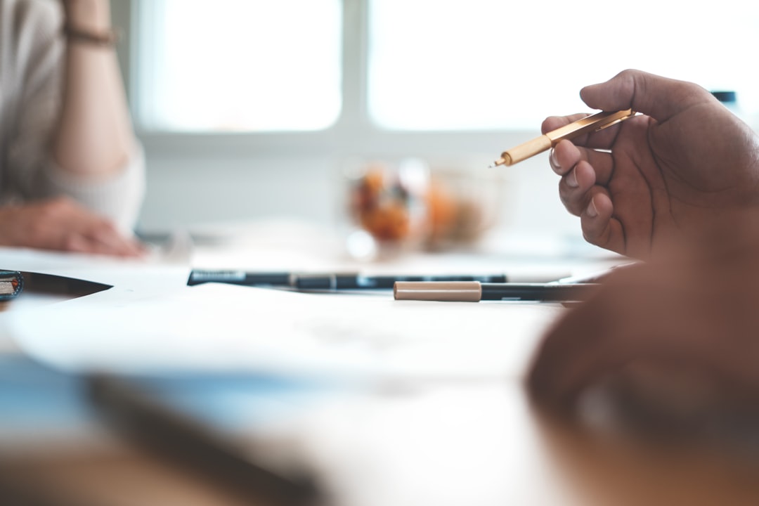 shallow focus photo of person wearing ballpoint pen