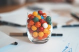 multicolored balls in clear shot glass