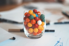 multicolored balls in clear shot glass
