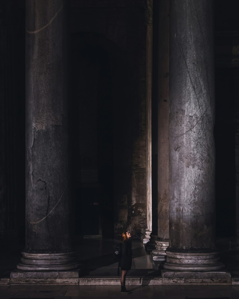 person standing near black concrete pillar post