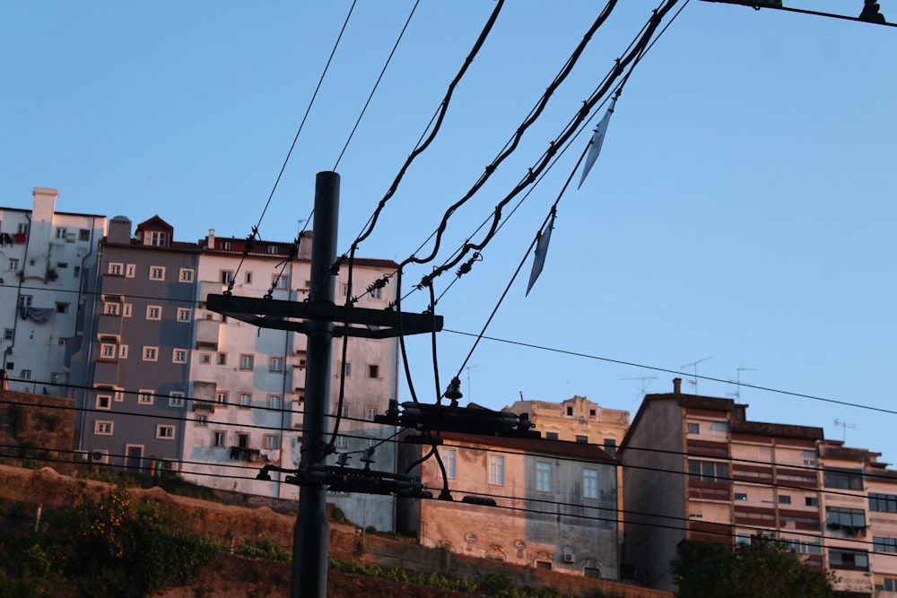 Schwarze Strommasten in der Nähe von Bergen mit Gebäuden