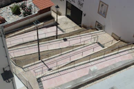 A sunny outdoor patio area with ramps and handrails for safe community access.