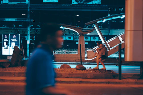 A cinematic video frame showing a musician walking through a city at dusk.
