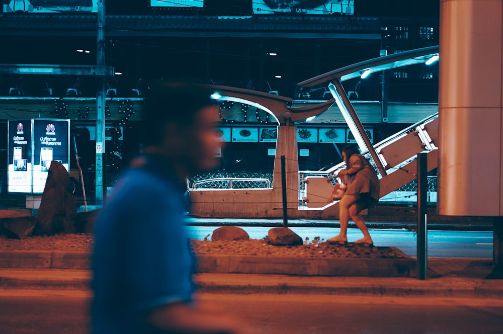 man wearing blue shirt walking during night time