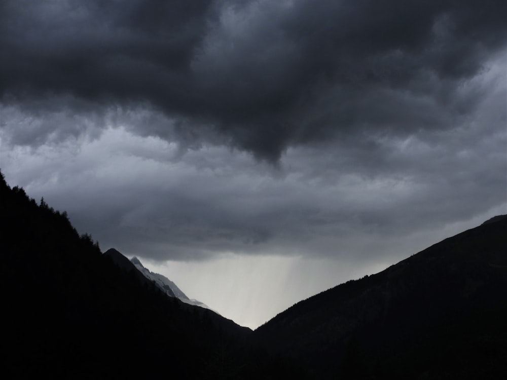 silhouette of mountain under gray skies