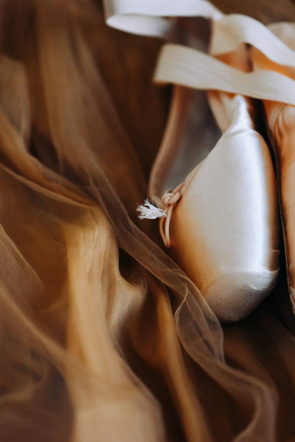 a pair of ballet shoes laying on top of a bed