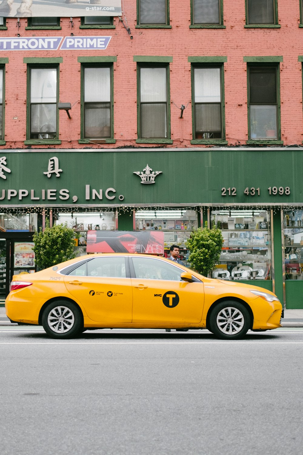 yellow sedan in road near building during daytime