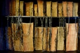 A row of old, leather-bound books is lined up on shelves, secured by metal chains. The books have worn pages and weathered spines, suggesting they are antiquarian or rare editions.