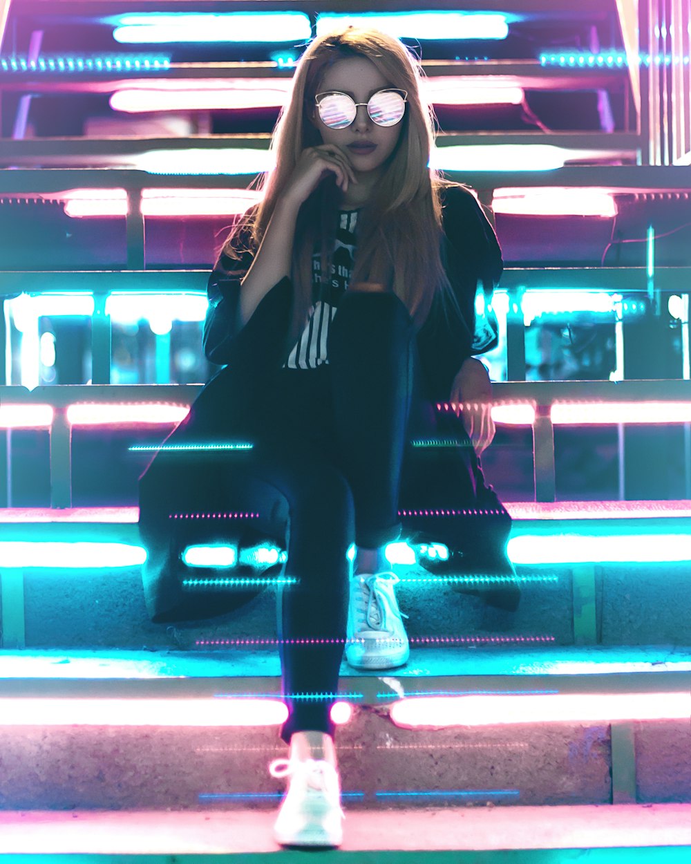 Femme assise sur des escaliers en métal avec des lumières