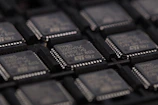 Rows of memory chips neatly arranged on testing racks in a cleanroom.
