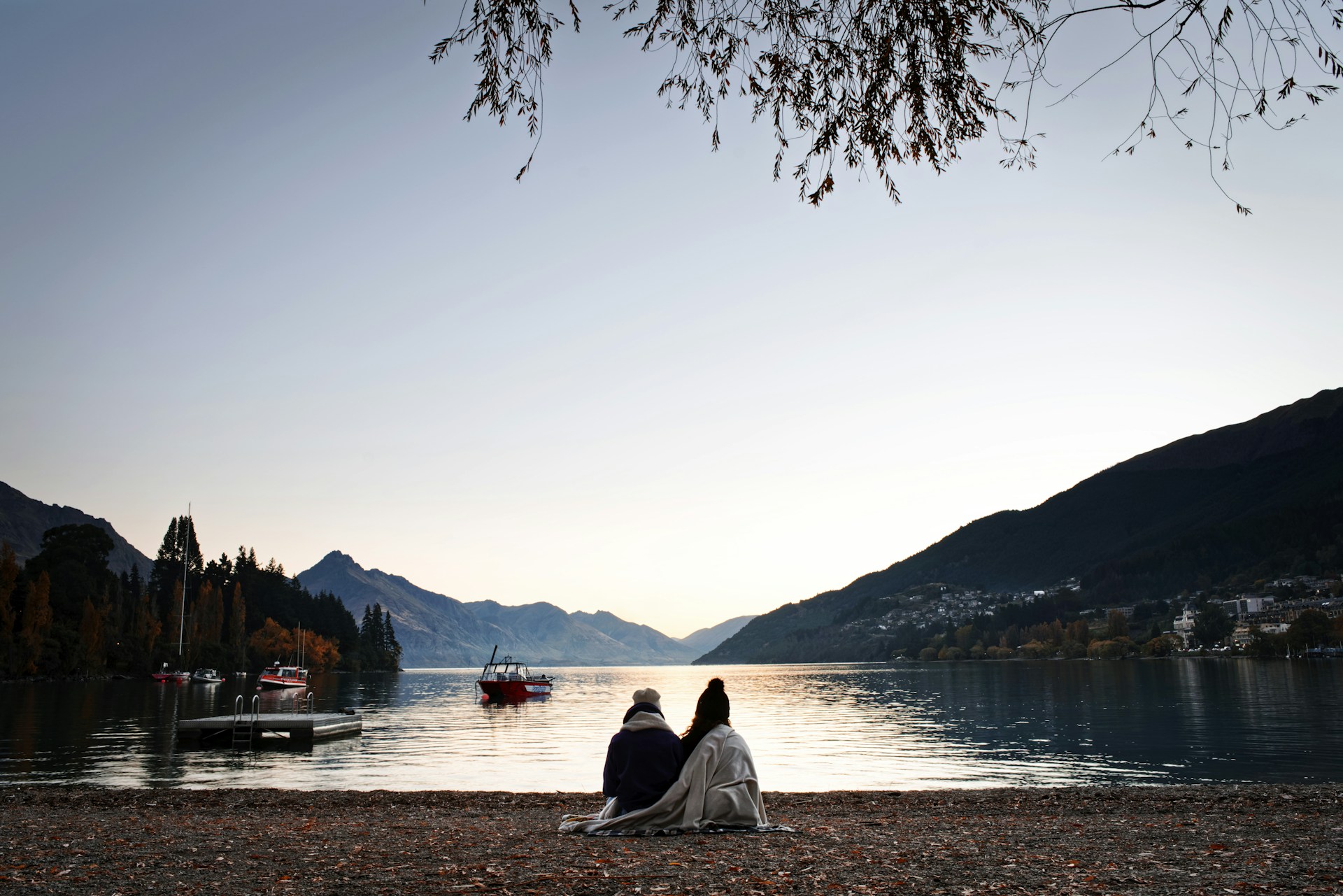man and woman sitting on sea shore