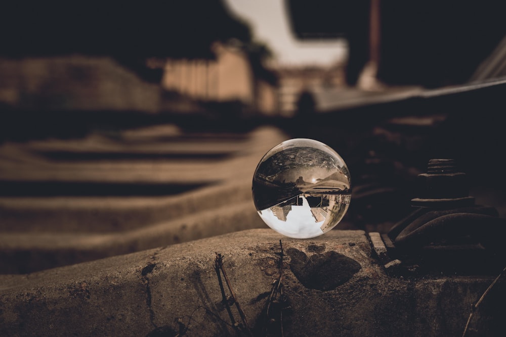 boule de verre transparent sur chaussée grise