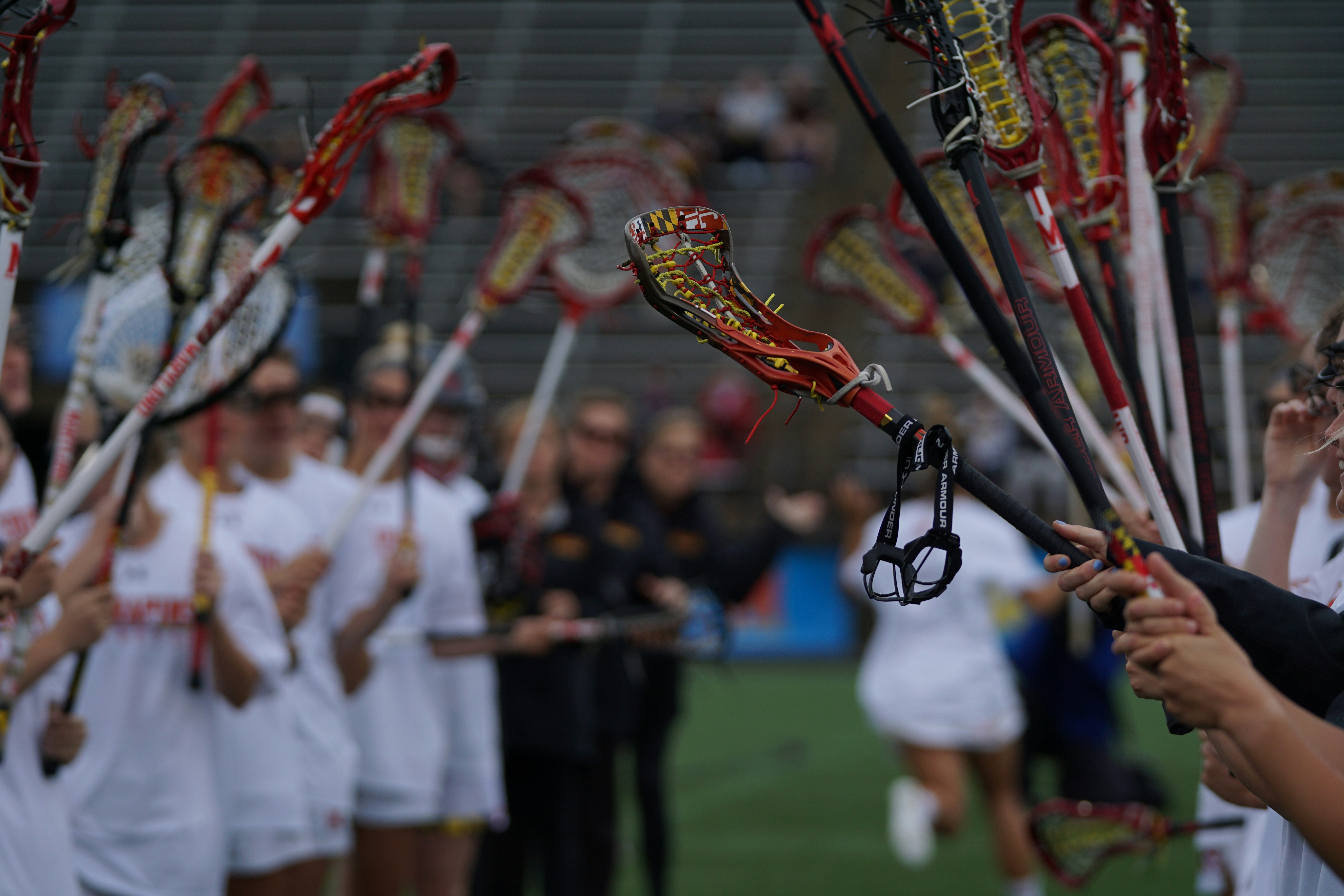 people holding lacrosse sticks