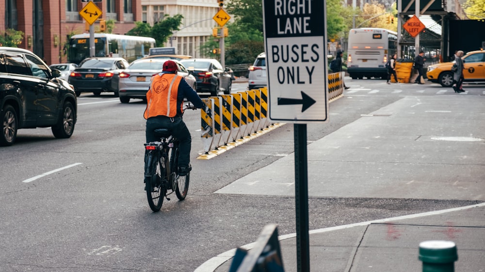 man riding bicycle on street near cars