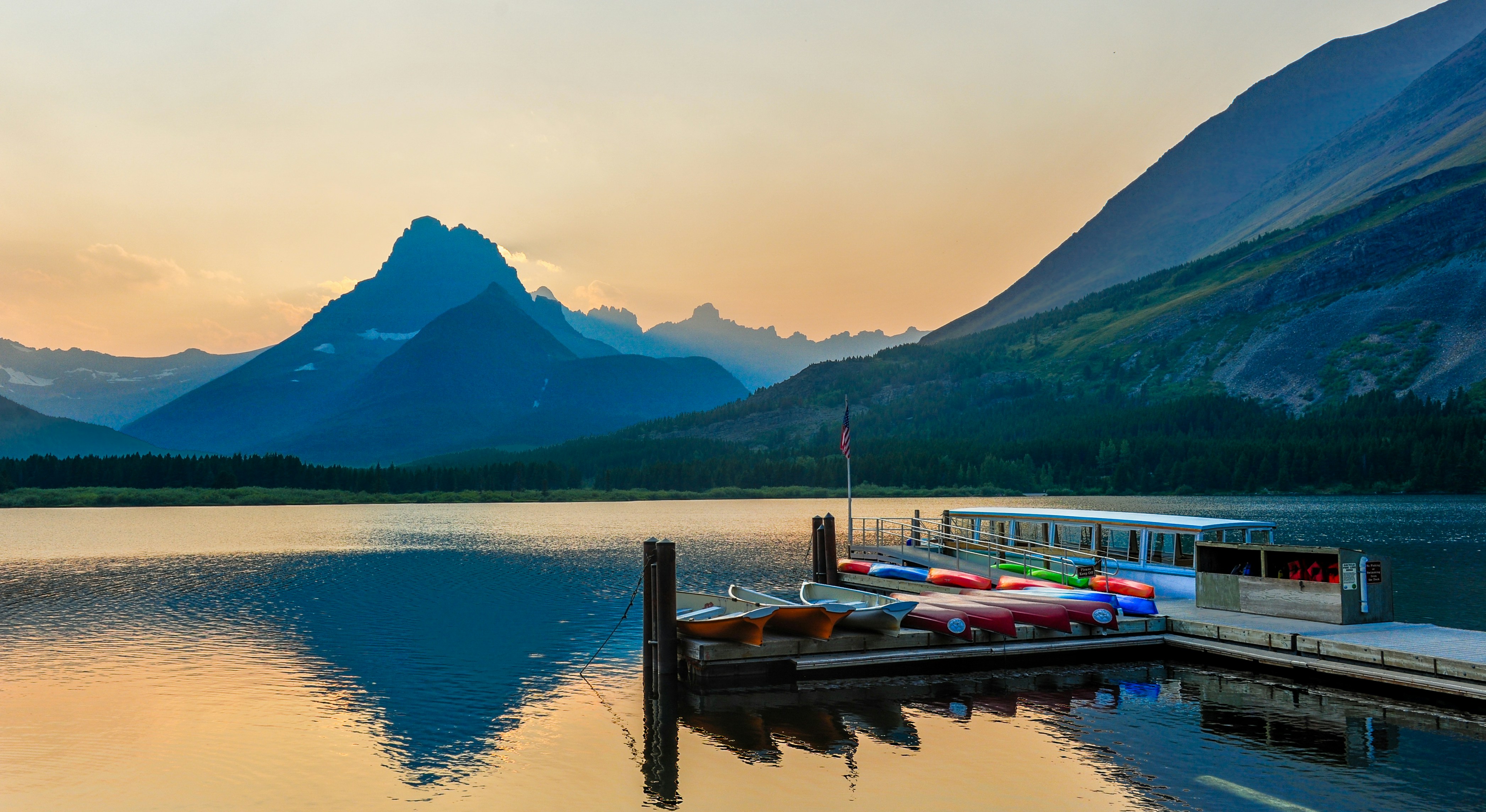boat parked in dock during daytime, After a hiking trip in Glacier National Park we had a rest at this nice hotel with this splendid view. 