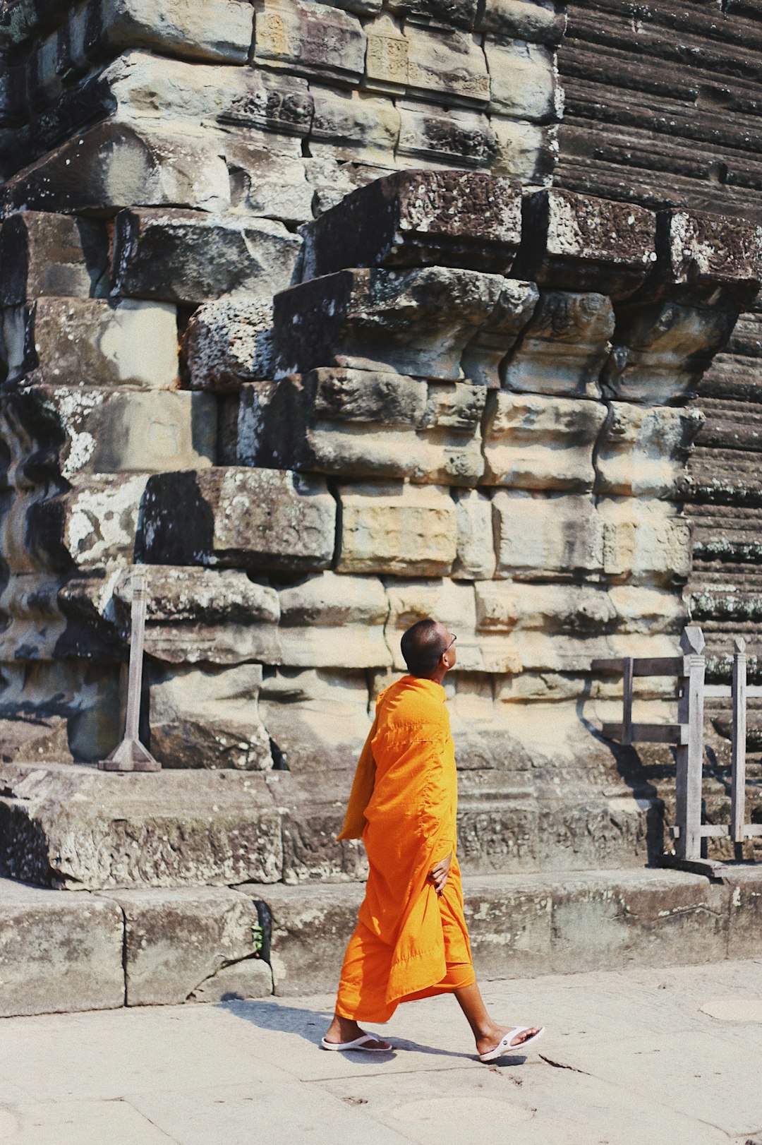 monk walking along sidewalk while looking up
