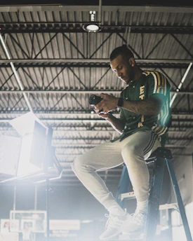 Technician repairing a CCTV camera with tools on a ladder.